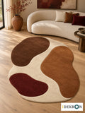 Geneva Escalade Ember: hand-tufted wool rug in ivory, cocoa brown, cinnamon brown and oxblood, in a modern living room with coordinated art.